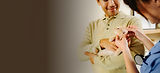A kitten being held by their parent and examined by a vet