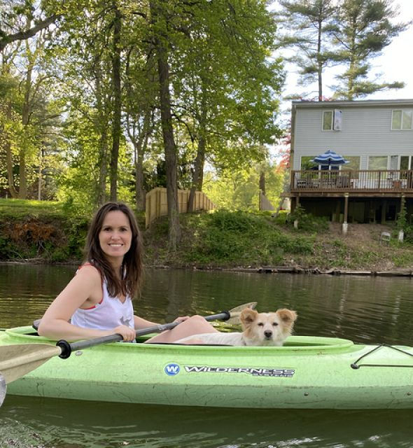 Portrait of Courtney kayaking with her dog 